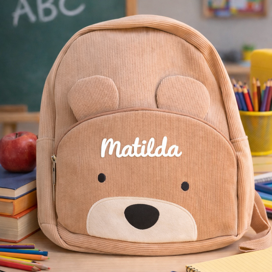 Children's backpack with bear design and 'Matilda' branding in a classroom setting.