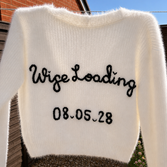 A cream-colored fuzzy knit sweater with 'Wife Loading...' and the date '08.05.28'